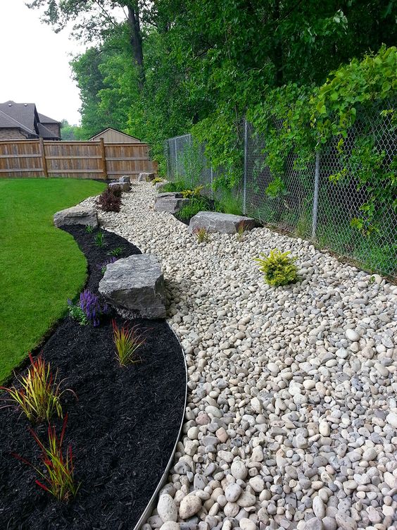 backyard border made of rocks, with mulch