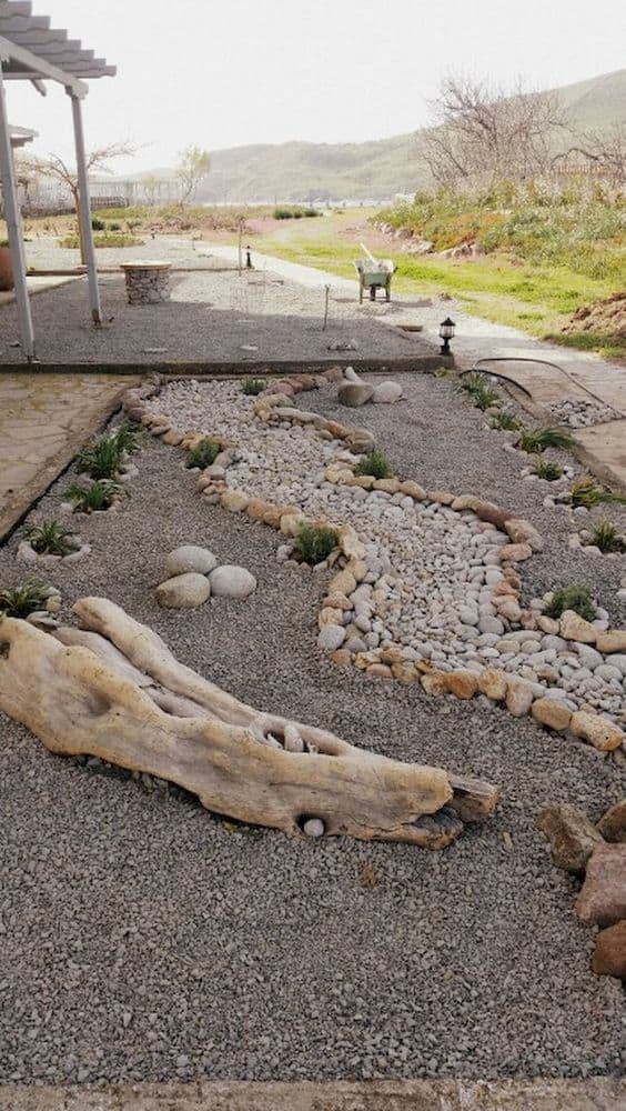 Dry river bed landscaping ideas:empty space in your yard by filling it with small stones