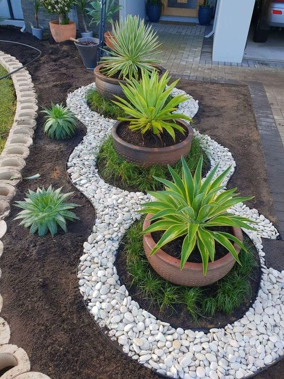 white rocks to highlight big potted plants  #flowers #garden #flowerbeds #Hardscaping #mulch #rocks #backyardLandscaping #backyardLandscapingIdeas #landscaping #cheapLandscapingIdeas #backyard #landscaping #curbAppeal