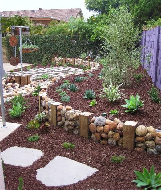elevated garden bed with stones and wood on the edges  #flowerbeds #flowers #garden #backyardLandscaping #backyardLandscapingIdeas #landscaping #cheapLandscapingIdeas #backyard #landscaping #curbAppeal #curbAppeal