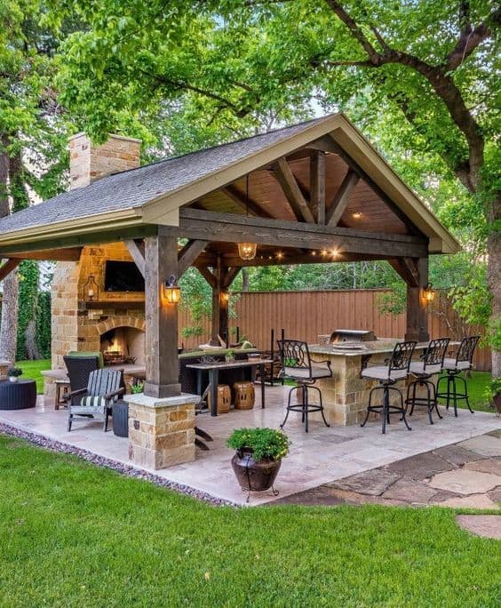 luxurious backyard pavilion with dinning are, fireplace and kitchen  #backyard #backyarddesign #outdoordecor #outdoorliving  #backyardDecor #backayrd #backyardParty #outdoorPartyIdeas #patioFurniture #outdoorKitchen #backyardKitchen 