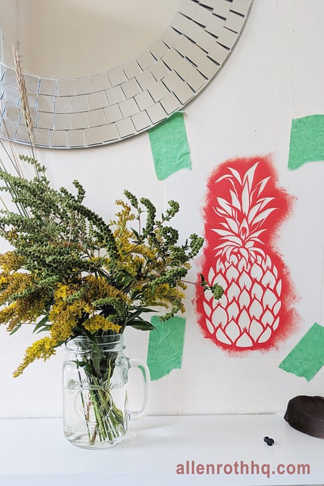 DIY wall stenciling: taping the stencil on the wall #diy #stenciling #frontdoor #pineapple #homeDecor #anestwithayard #stencil #wallstencil