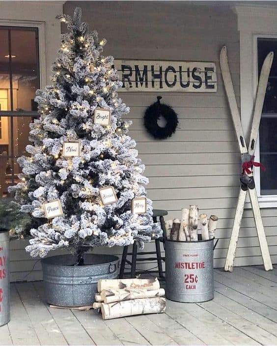 winter theme Christmas tree on a metal planter #porchIdeas #porch #winter #frontDoorDecor #homeDecor #patiodecor  #christmasTree 