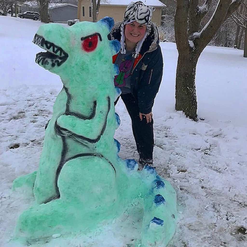 Woman posing with dino snow sculpture