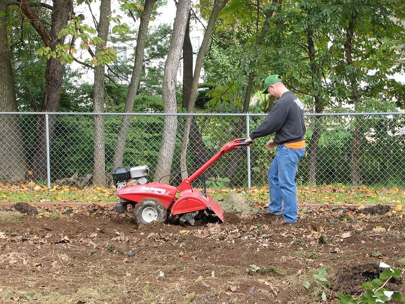 A red rototiller getting to work