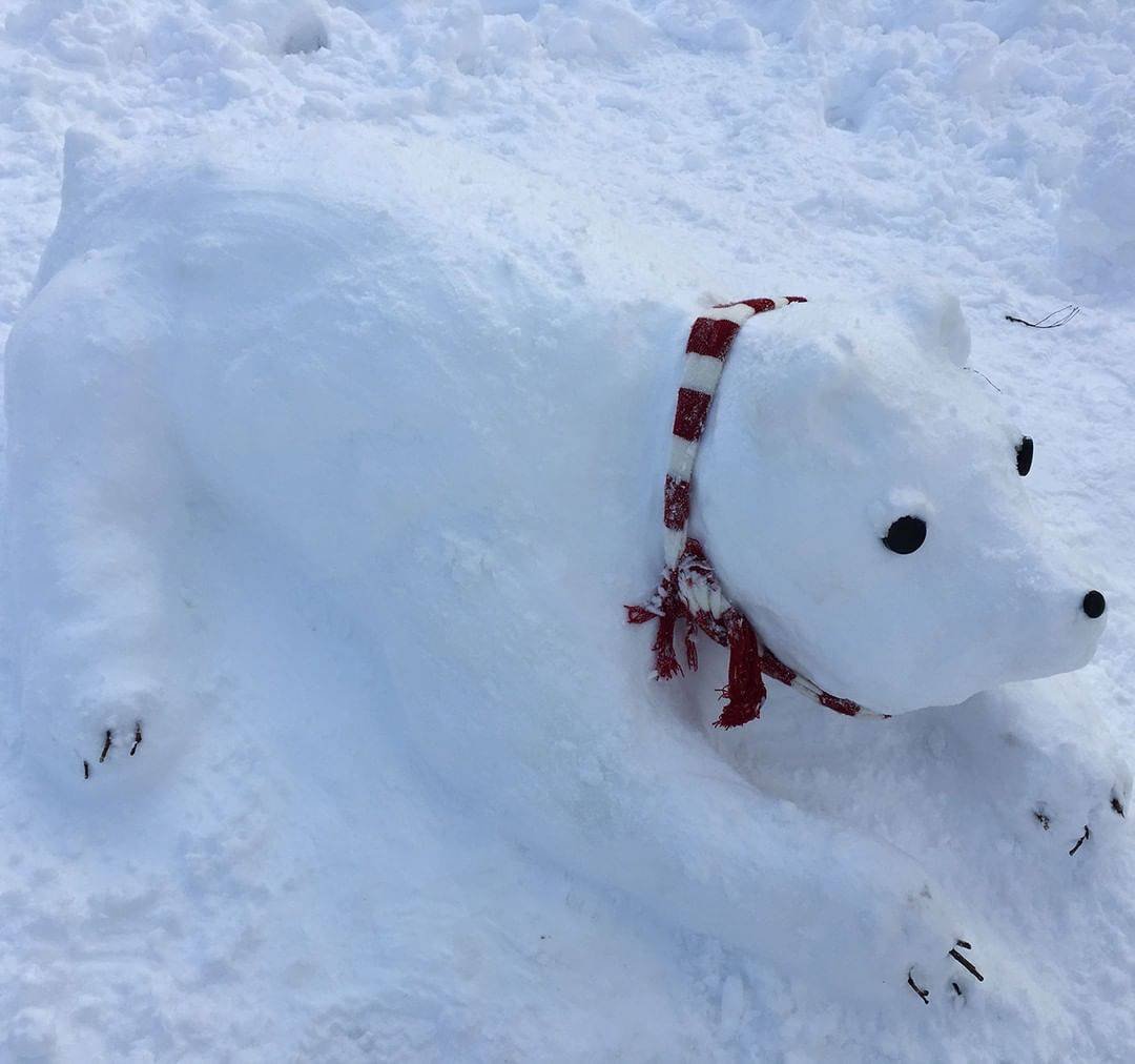 A snow sculpture bear wearing scarf