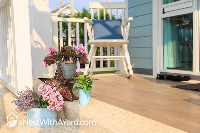 Porch decorated with pink flowers and a rocking chair