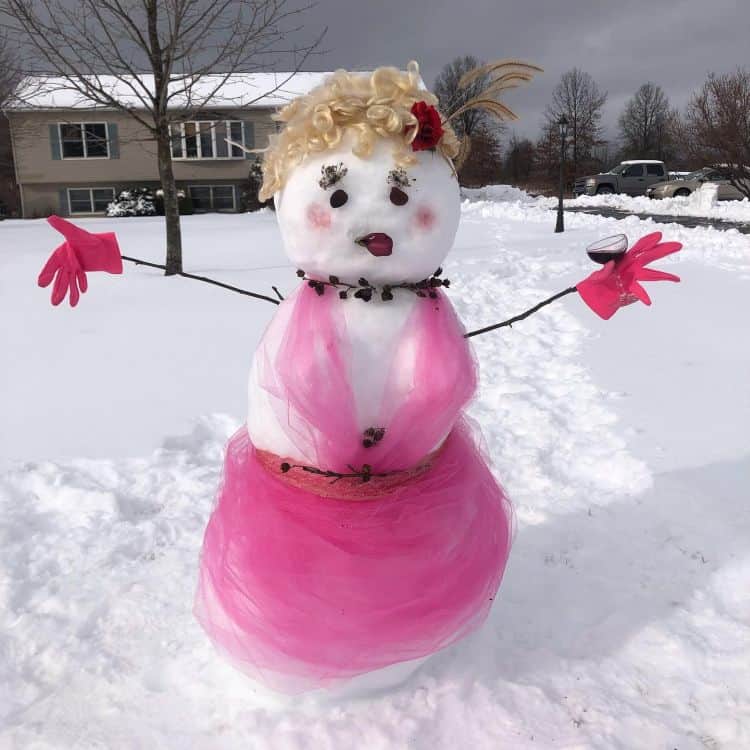 Snow woman statue decorated with pink clothes