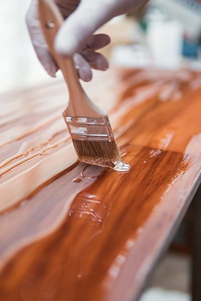 A slab of wood being applied with resin overlay