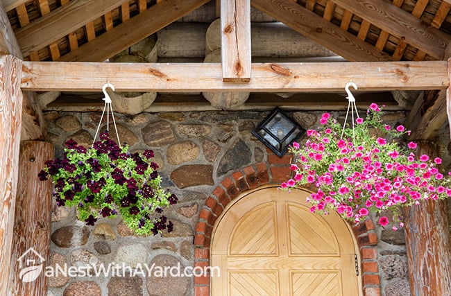 hanging baskets with flowering plants in bloom as porch decor