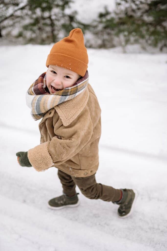 A child happily running in the snow