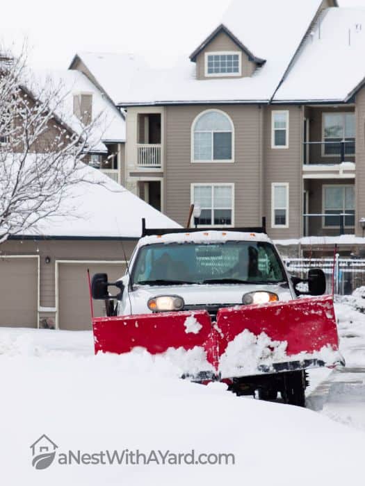 A vehicle with a red snow plow attached