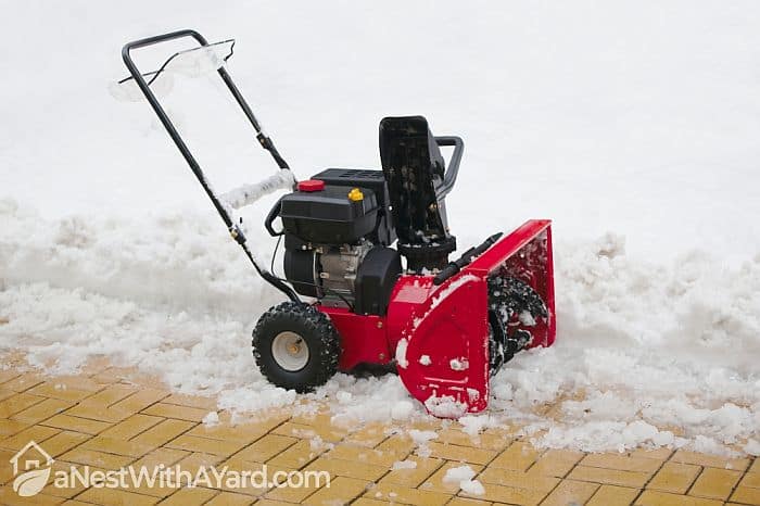 A gas powered snow blower on stand-by