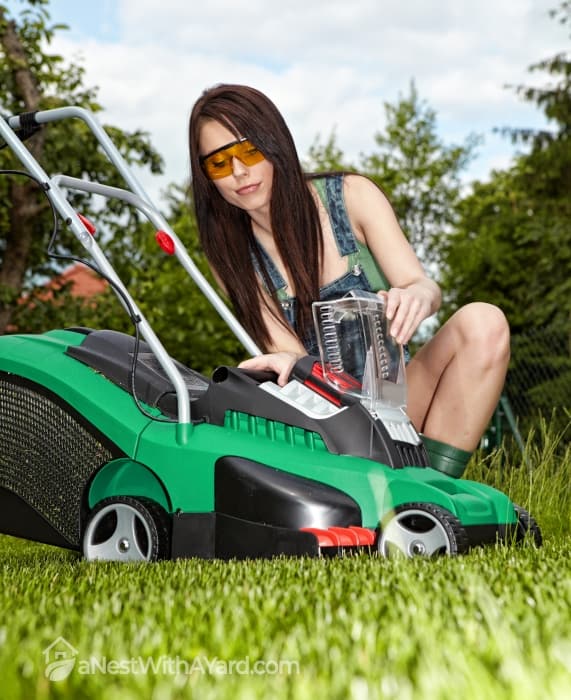 Woman inspecting a lawnmower