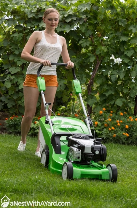 Young woman mowing the lawn